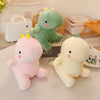 Three soft plush dinosaur toys in pink, green, and yellow colors displayed on a white table.