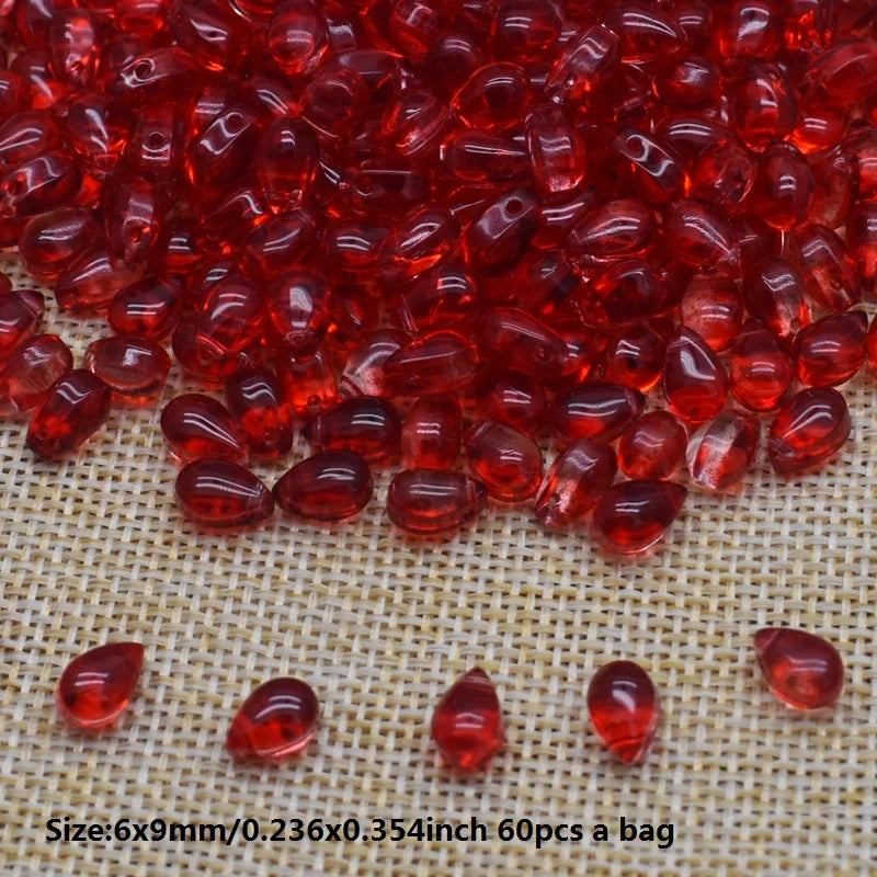 A pile of translucent red water drop Czech glass beads for jewelry making