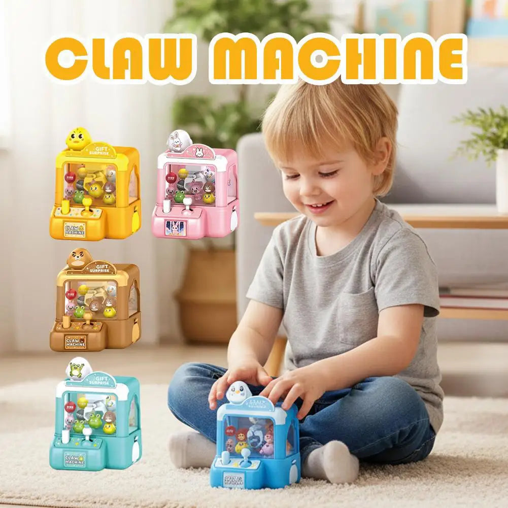 A young boy is playing with a colorful mini claw machine toy for kids.