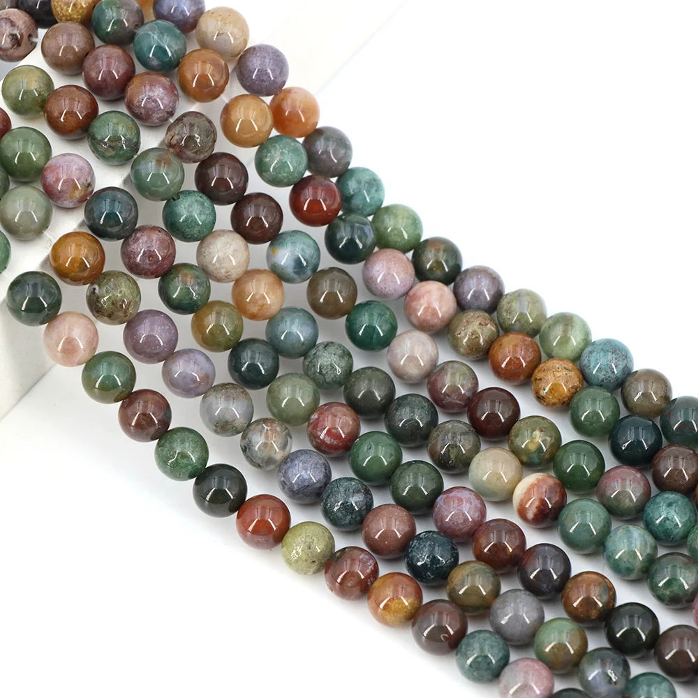 A string of round loose agate beads in various shades of green, brown, and purple stones for jewelry making