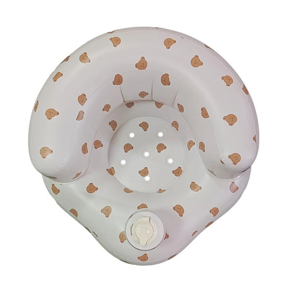 A round, white inflatable baby sofa with light brown scattered patterns and a control knob.