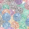 A close-up view of various round glitter cracked acrylic beads in shades of purple, pink, blue, and green.
