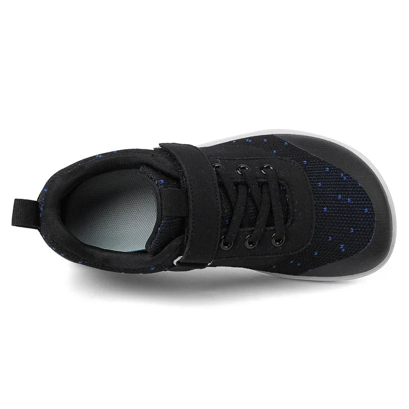Black kids barefoot training sneakers with wide toe box shown from the side.
