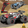 A red off-road monster truck RC car is shown on sand, with a remote control unit nearby.