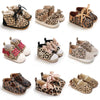 A collection of leopard print soft sole baby sneakers in various styles and colors.