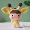 A handmade crochet doll kit featuring a yellow body, pink face, and brown ears with black eyes.