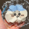 A white squishy toy shaped like a fluffy cloud with black facial features is sealed in clear plastic packaging.