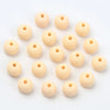 A collection of light beige matte acrylic beads shaped like macarons, arranged in a circular pattern.