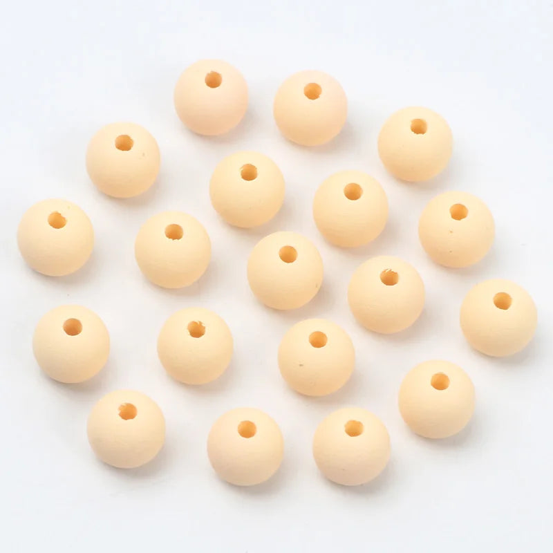 A collection of light beige matte acrylic beads shaped like macarons, arranged in a circular pattern.