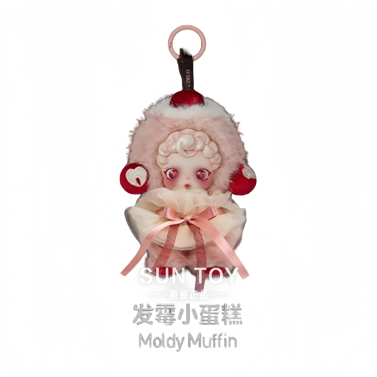 A pink Moldsy muffin collectible figure with large eyes and a bow tied around its body.