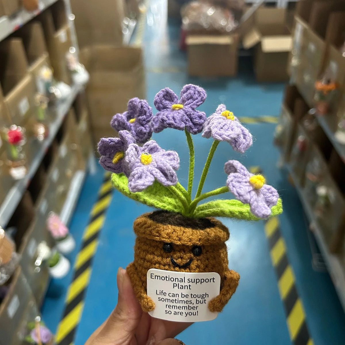 Handmade crochet plant with purple flowers in a brown pot and green leaves