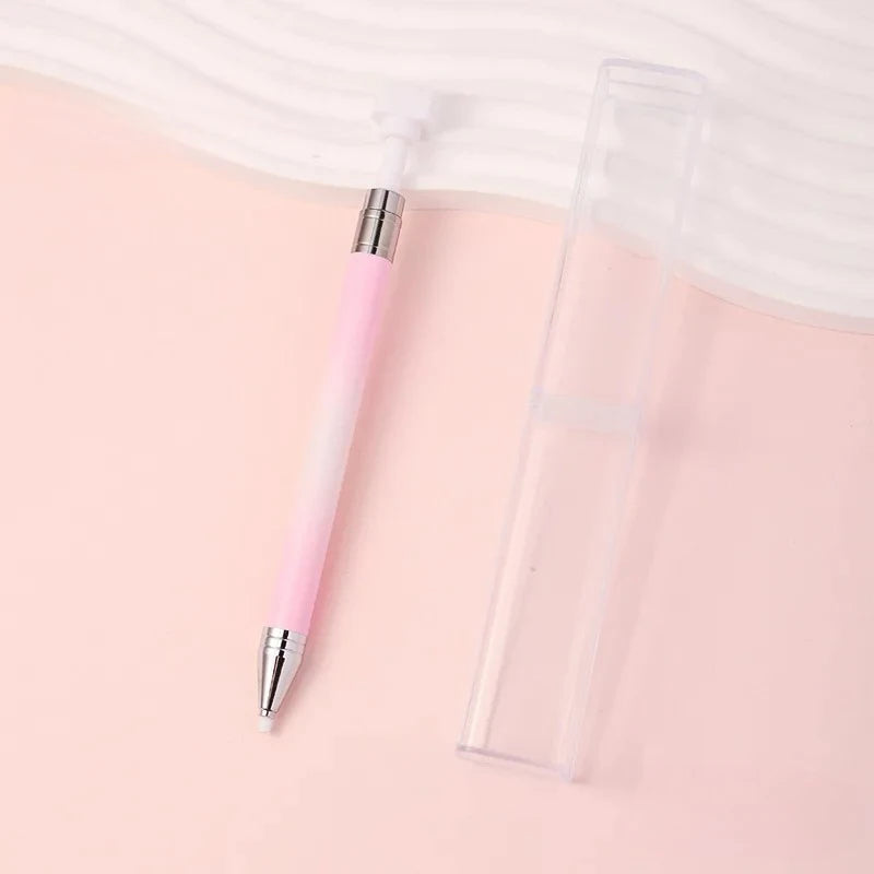 A pink refillable diamond picking pen with a rotating wax tip for nail art displayed on a light pink background.