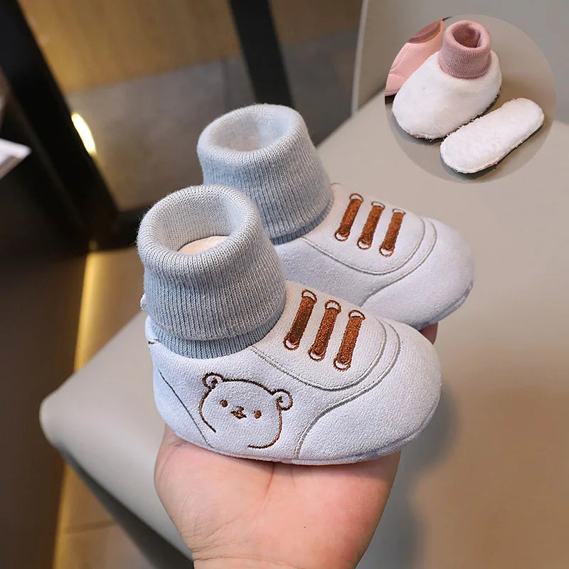 A pair of light gray knit bear booties for a baby, shown against a neutral background.