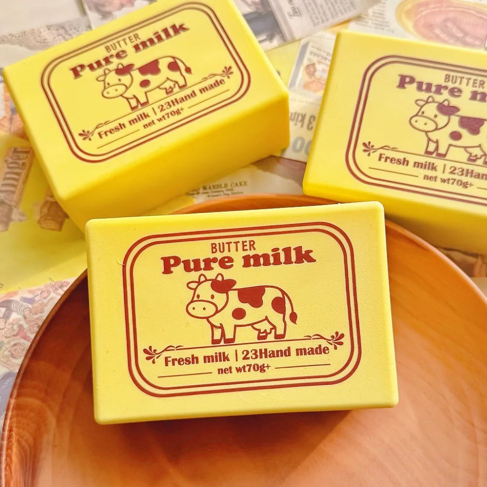 Yellow butter pure milk squishy toys in square packaging displayed on a wooden plate.