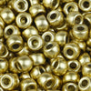 A close-up view of small, gold-colored pony beads for jewelry making and crafts.