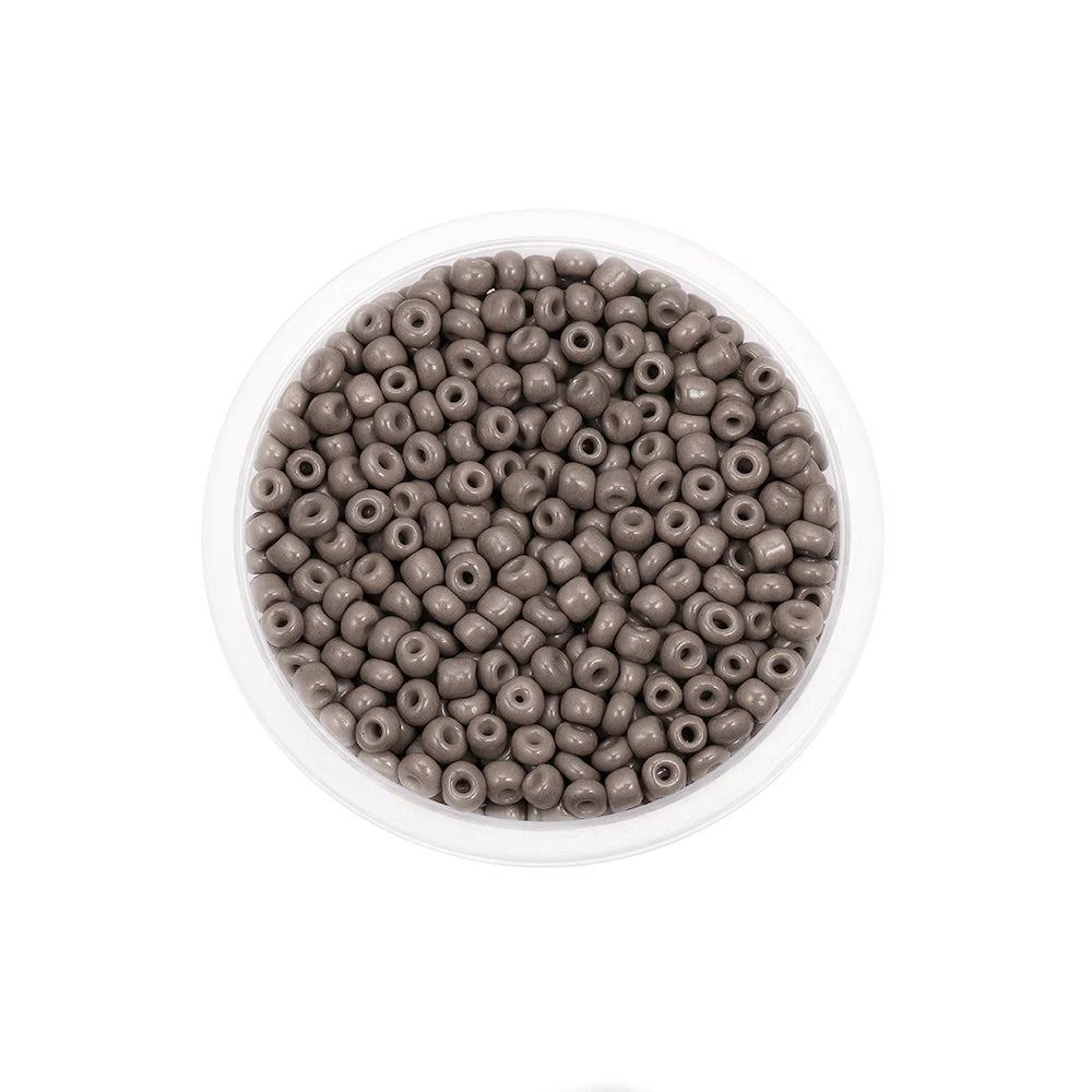 A clear container filled with small, round, brown glass seed beads for jewelry making.