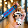 A hand holds a Michael Jackson music icon keychain with a metal buckle and a blue tag.