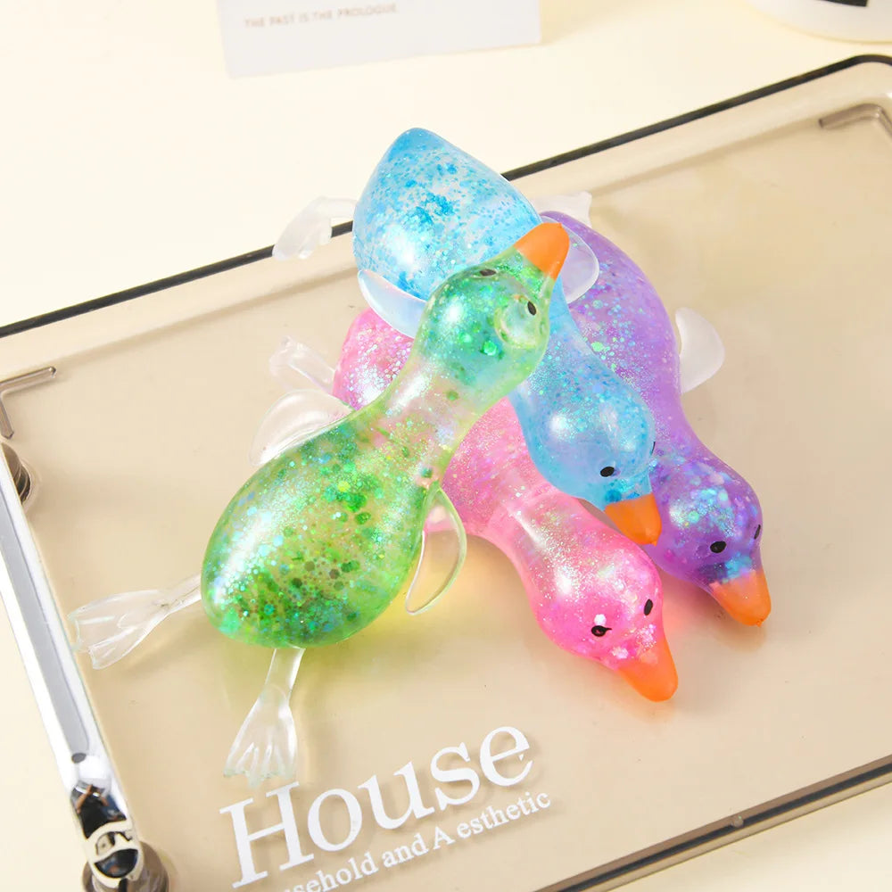 A collection of colorful, iridescent duck squeeze toys on a light tray.