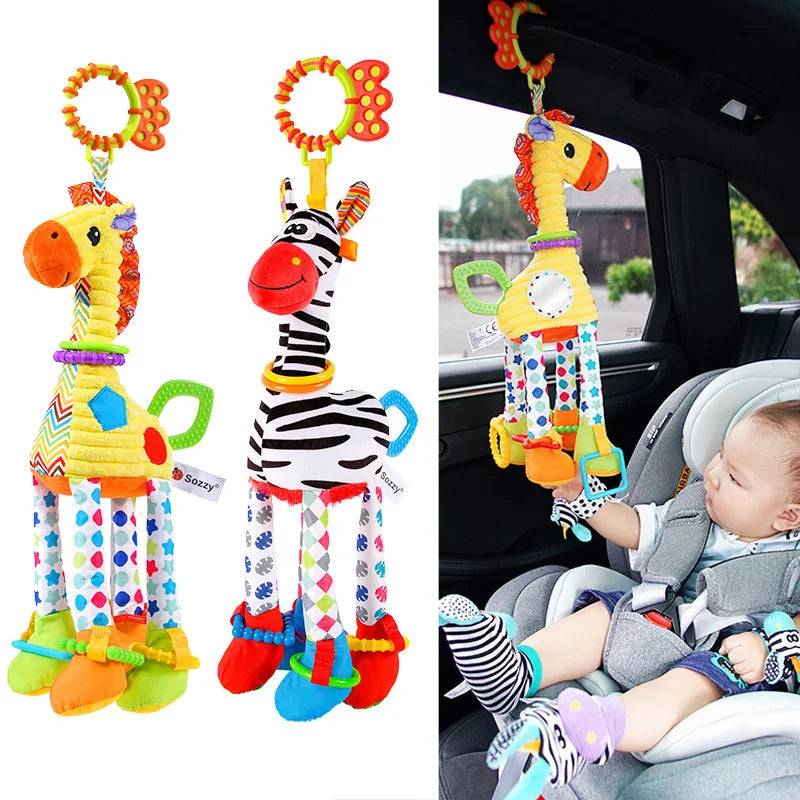 Plüschspielzeug aus Giraffe und Zebra mit Handglocken, gehalten von einem Baby.