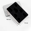 A silver plastic case holding a set of black resin polyhedral dice for tabletop gaming.