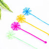 Colorful stretchy spider web toys in blue, yellow, pink, and green on a white background.