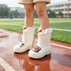 A pair of white waterproof bear rain boots with anti-slip soles standing on a wet running track.
