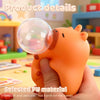 An orange capybara squeeze toy is being held in a hand, demonstrating its smooth and delicate PU material.