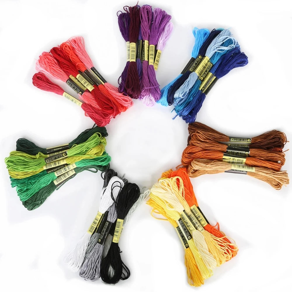 A set of multicolor embroidery floss skeins in various shades including pink, purple, blue, green, and orange.