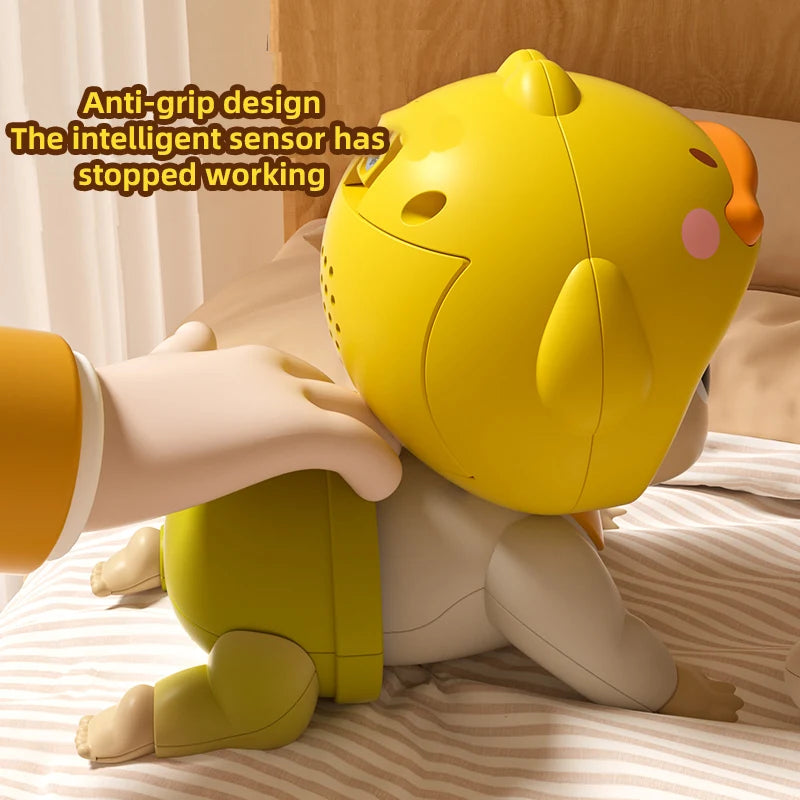 A yellow interactive crawling baby doll is shown lying on a striped bed, with an adult hand interacting with it.