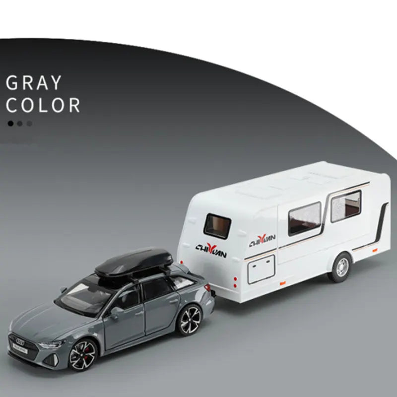 A gray diecast model of an RV camper truck is shown next to a white van model.