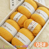 A box filled with eight balls of yellow wool yarn for knitting