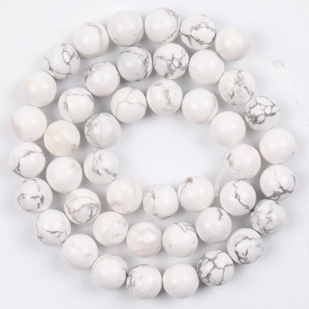A strand of round white and gray marbled beads used for jewelry making