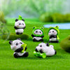 A set of adorable resin panda and frog figurines in green and white sitting on bright green grass.