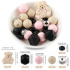A white dish holds various pink and beige silicone beads shaped like teddy bears, round balls, and geometric pieces for jewel
