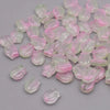 A pile of translucent pink and clear glass beads shaped like tulip flowers.