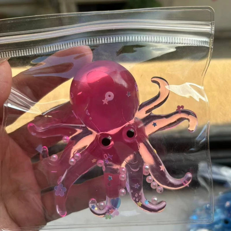 A pink squishy ocean octopus fidget toy is visible inside a clear plastic bag being held by a hand.