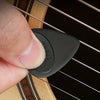 A hand holds a black guitar pick with an anti-slip grip, showing the size and shape of the pick.
