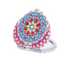 A folding mirror with a pink and blue floral design on the cover.