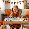 A young girl is playing with a set of colorful squishy stress relief toys on a wooden table.
