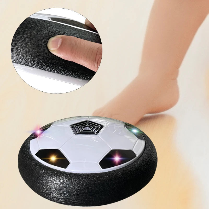 A black soccer ball with glowing LED lights is shown next to a hand demonstrating its hover feature.