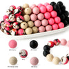 A collection of soft food-grade silicone beads in various colors including pink, black, and beige for DIY jewelry and crafts.