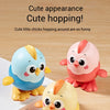 Three cute wind-up chick toys in blue, pink, and yellow are shown on a wooden surface.