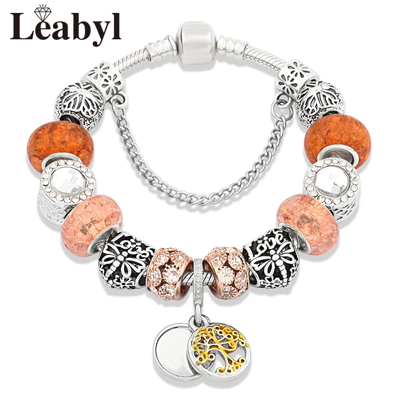 Silver charm bracelet featuring round amber beads and floral accents including a tree of life crystal charm