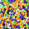 A close-up view of a pile of solid color pony beads in various shapes and sizes for jewelry making and craft projects.