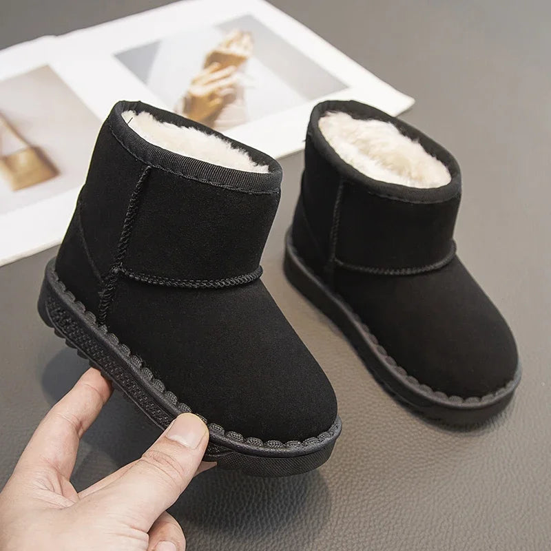 A pair of black, cozy fur-lined winter boots with a slip-on style shown being held by a hand.