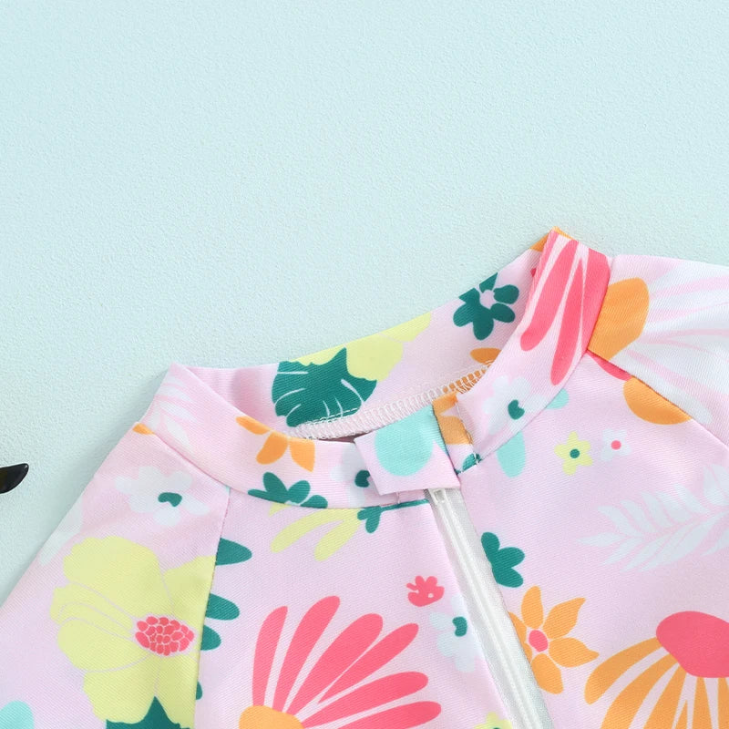 Pink baby rash guard swimsuit with floral print featuring green, yellow, and orange accents.