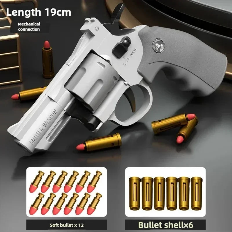 Pistolet jouet blanc avec poignée noire et balles dorées sur une surface sombre.