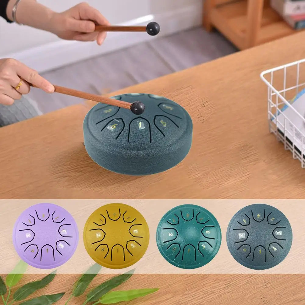 A set of portable steel tongue drums in various colors, including purple, yellow, teal, and gray, with wooden mallets.