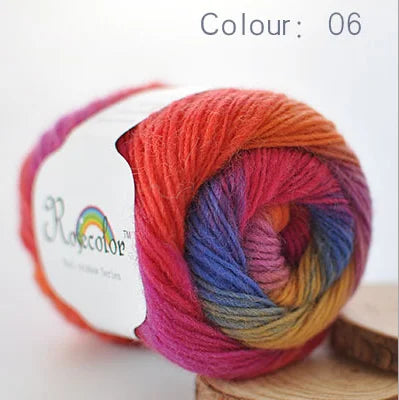 A ball of hand-dyed rainbow merino wool yarn in color 06, ready for knitting or crochet.