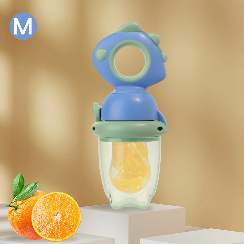 A dinosaur-shaped silicone feeder with a blue and green top is shown next to an orange.